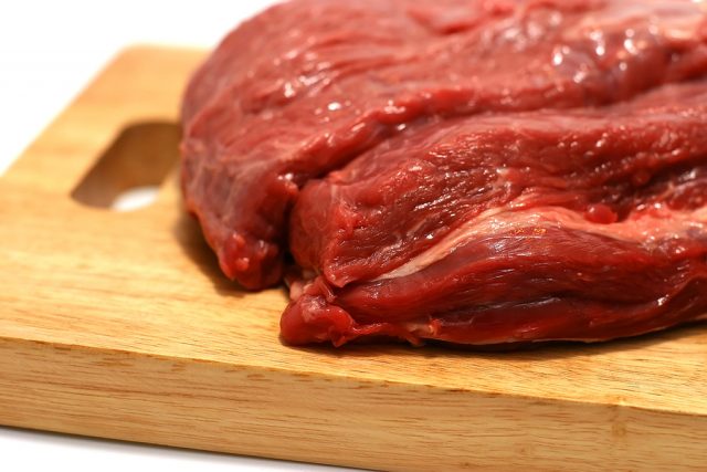 raw red meat on wooden plate