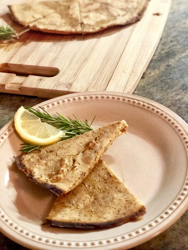 rosemary flatbread on a plate with a lemon garnish