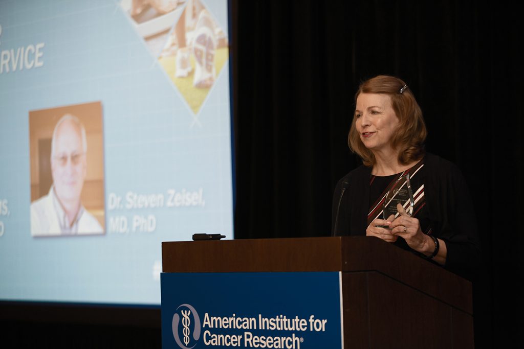 woman at podium during cancer research conference
